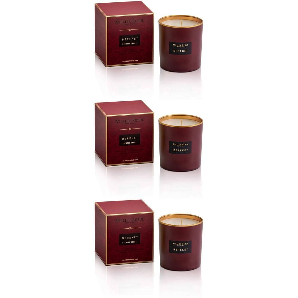 Trois bougies Bereket dans des contenants bordeaux avec des bords dorés et des étiquettes. Trois boîtes carrées assorties.