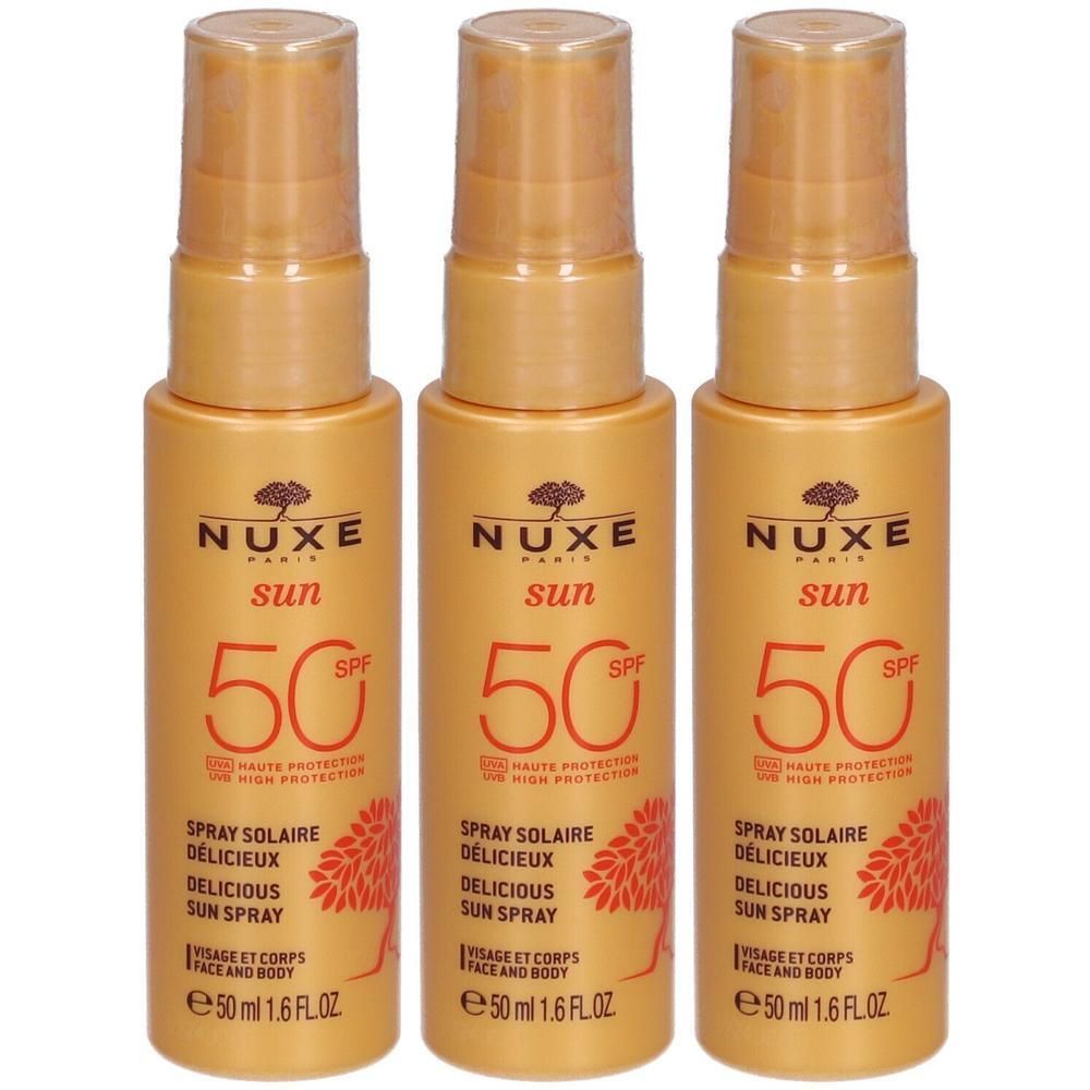 Drie gouden sprayflacons SPF 50. Opschrift: Nuxe Sun, Spray Solaire Délicieux, gezicht & lichaam. Met spraykop.