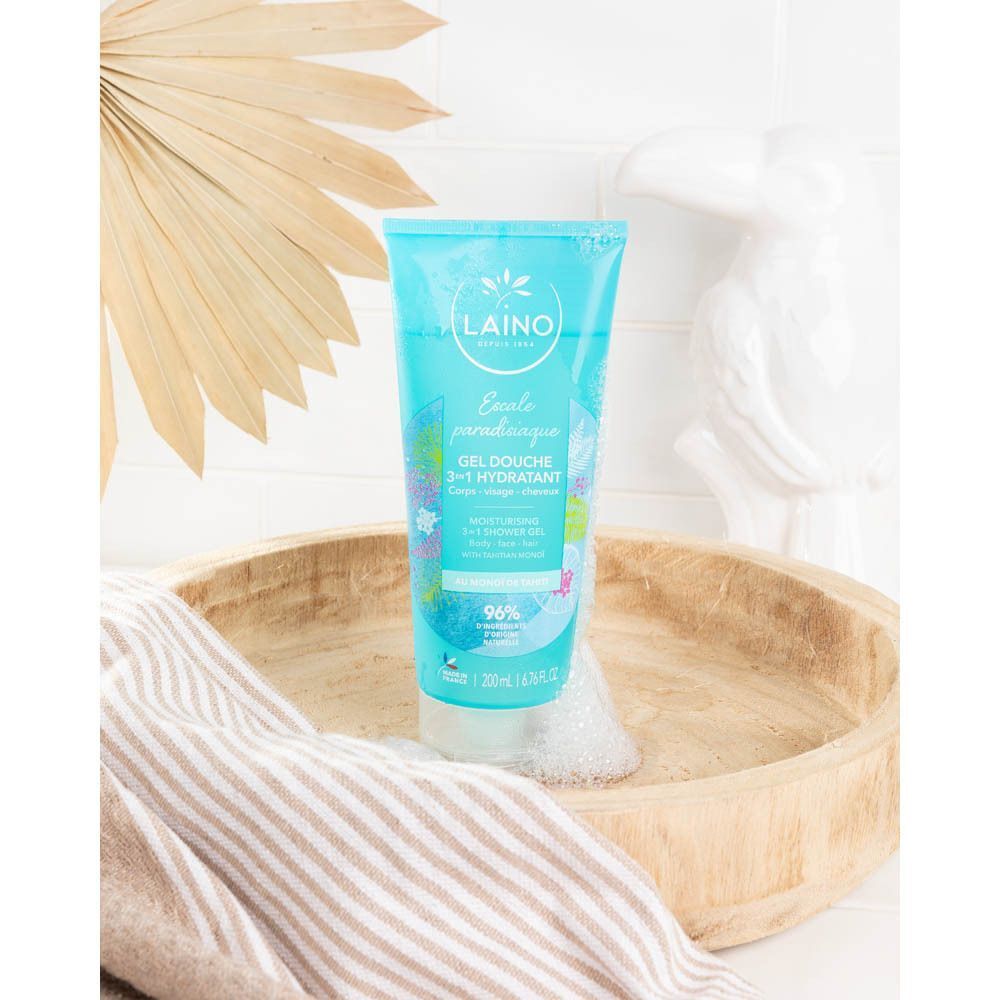 Tube de gel douche bleu dans un bol en bois. Inscription: Laino, Gel Douche Hydratant 3 en 1. Mousse et décoration.