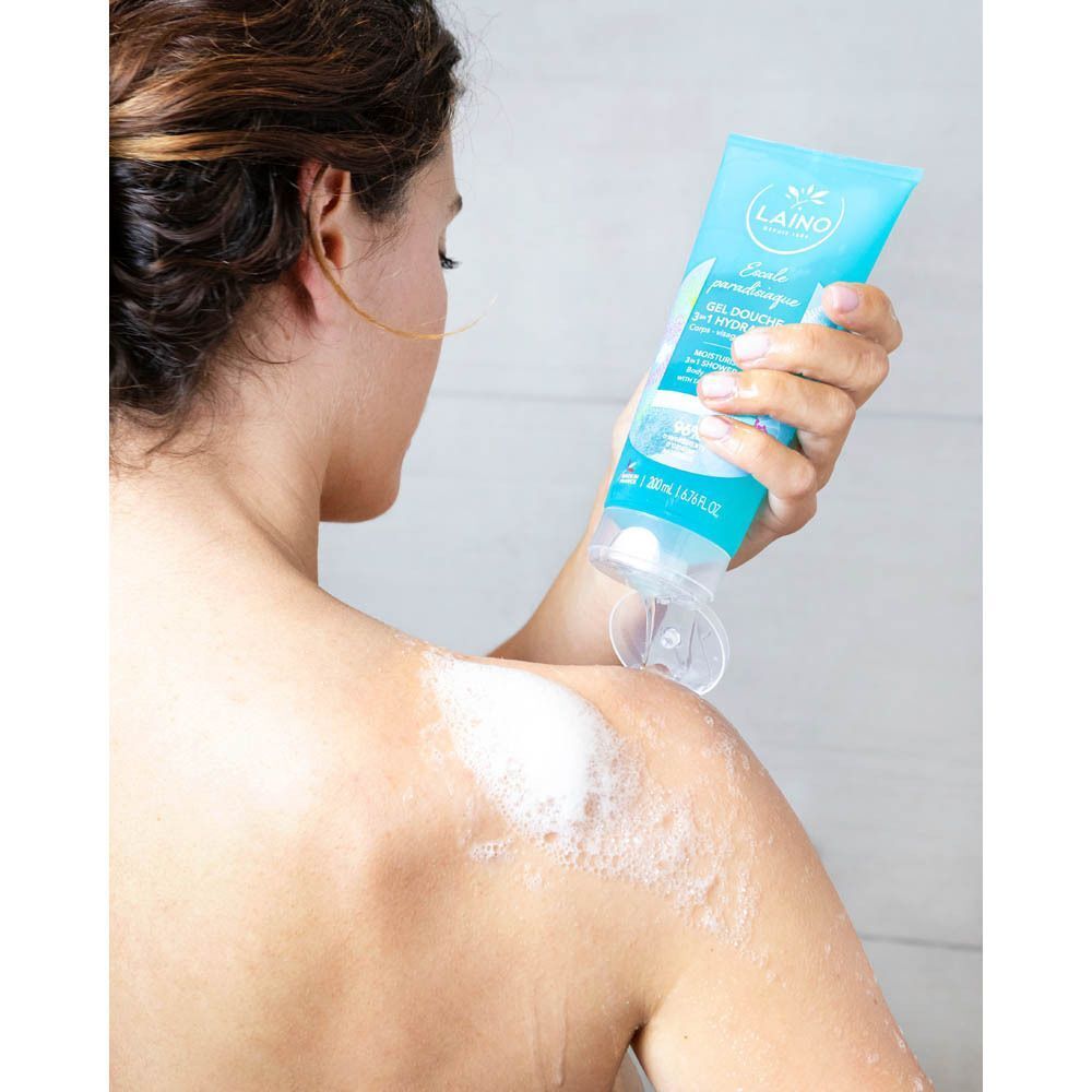 Personne se lavant avec du gel douche bleu. Inscription: Laino, Gel Douche Hydratant 3 en 1. Mousse sur l'épaule.