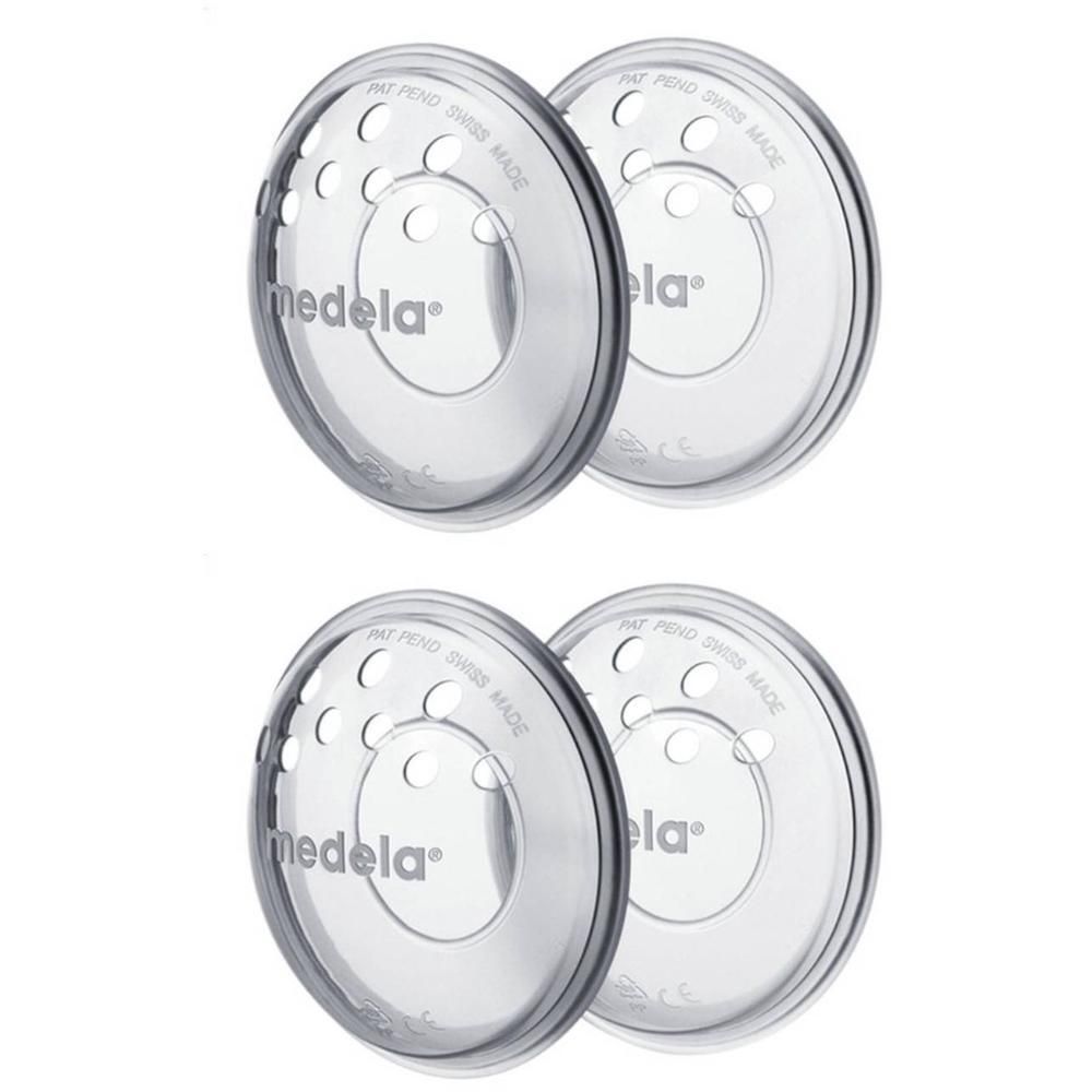 Deux coussinets d'allaitement Medela transparents avec trous d'aération et logo.
