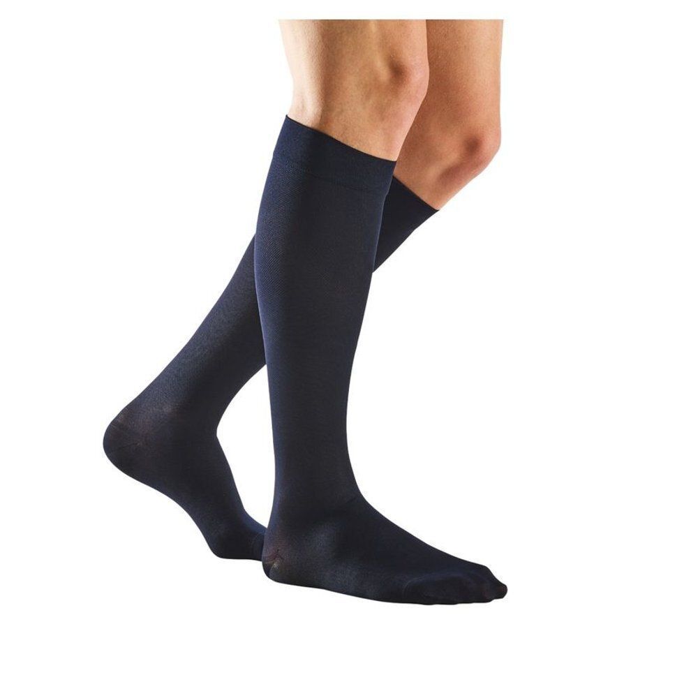 Une paire de bas bleus foncés en tissu fin, portés par un modèle.