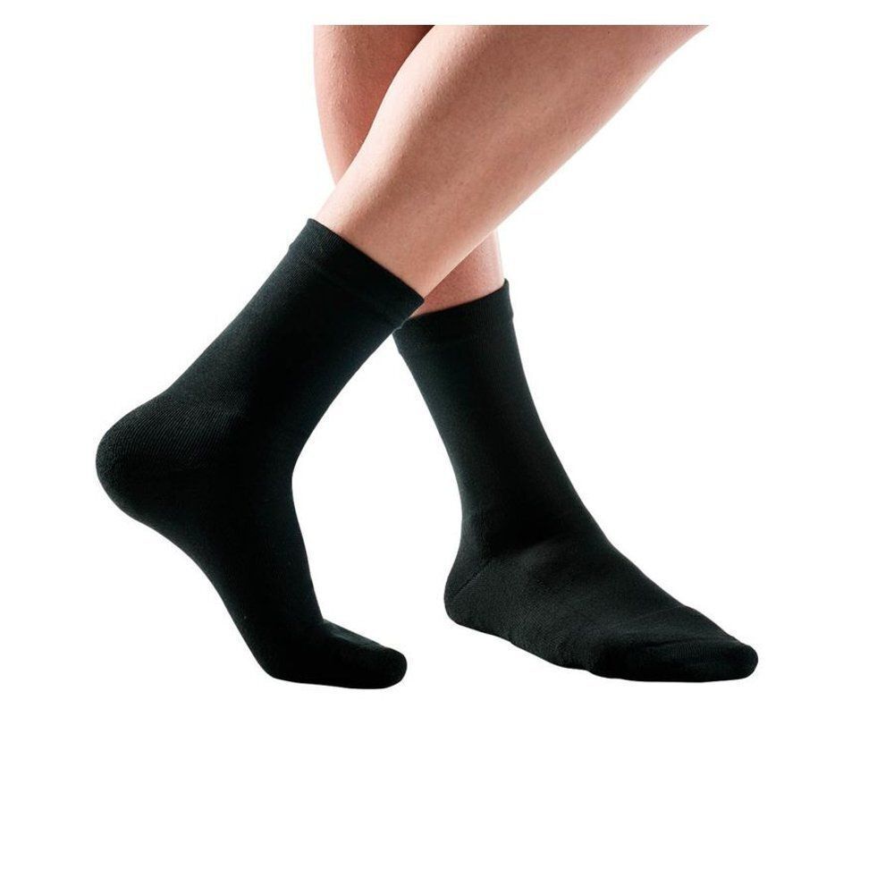 Deux chaussettes noires en tissu éponge, portées sur des jambes humaines.