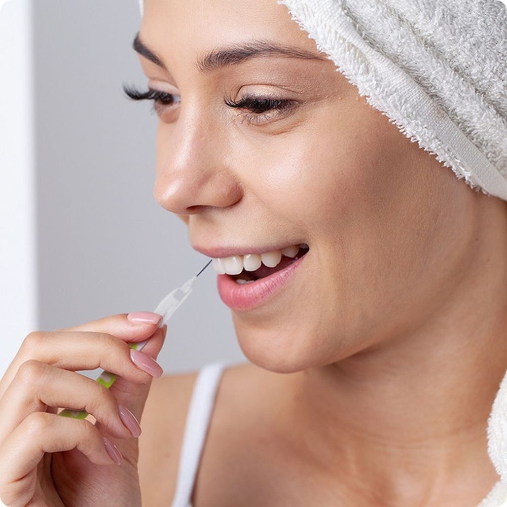 Vrouw gebruikt GUM Bi-Direction interdentale borstel voor mondhygiëne.
