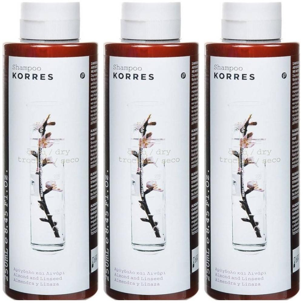 Drie flessen Korres Shampoo met Amandel en Lijnzaad. Witte etiketten met tak en bloesems.