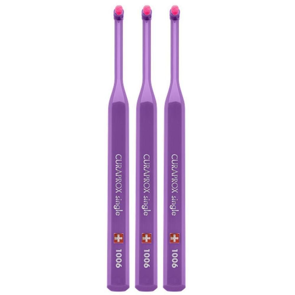 Drie paarse tandenborstels met smalle kop en roze borstels. Opschrift: CURAPROX single 1006.