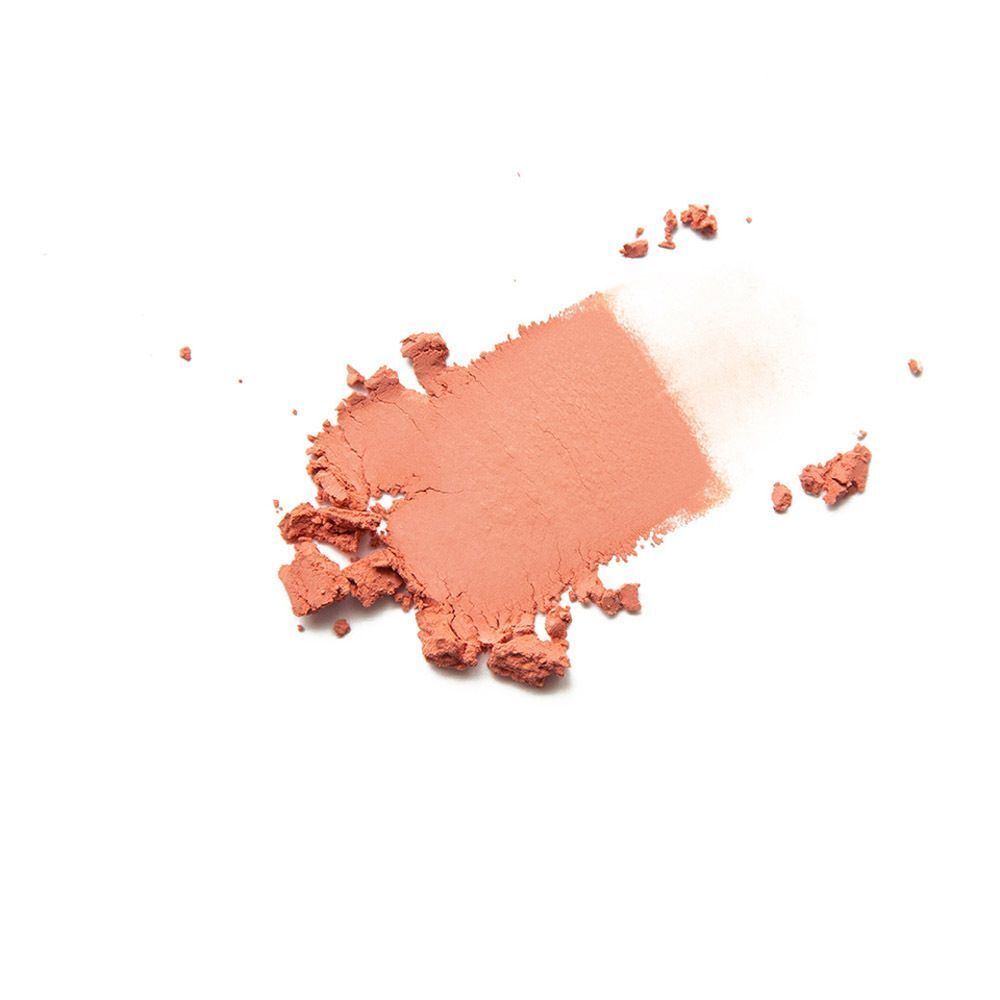 Een afgebakend gebied van los minerale blush poeder perzik op witte achtergrond.