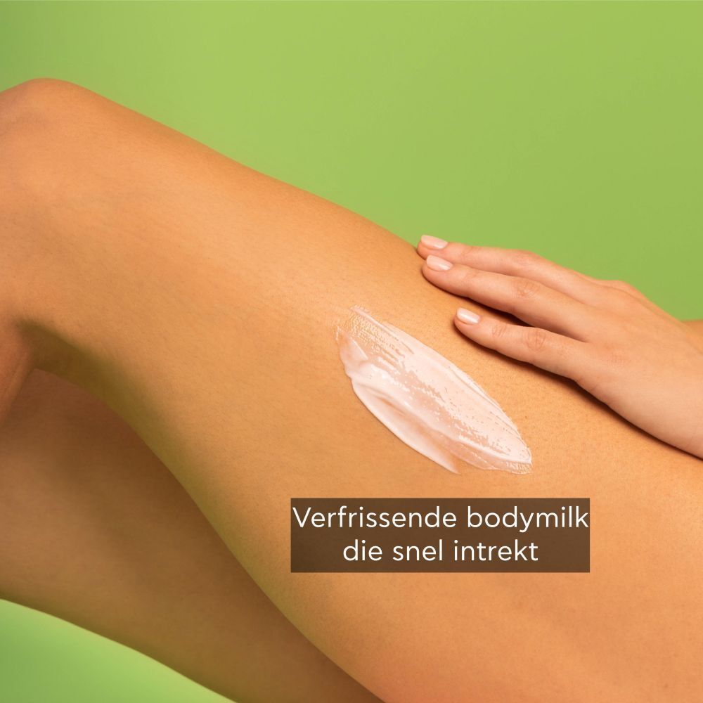 Hand brengt bodylotion aan op een dijbeen. Tekst over verfrissende lotion.