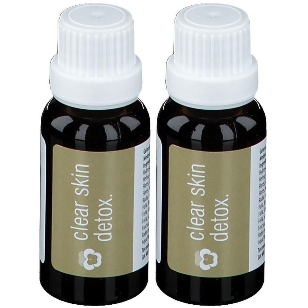 Deux flacons en verre foncé avec bouchons à vis blancs, étiquetés "clear skin detox."