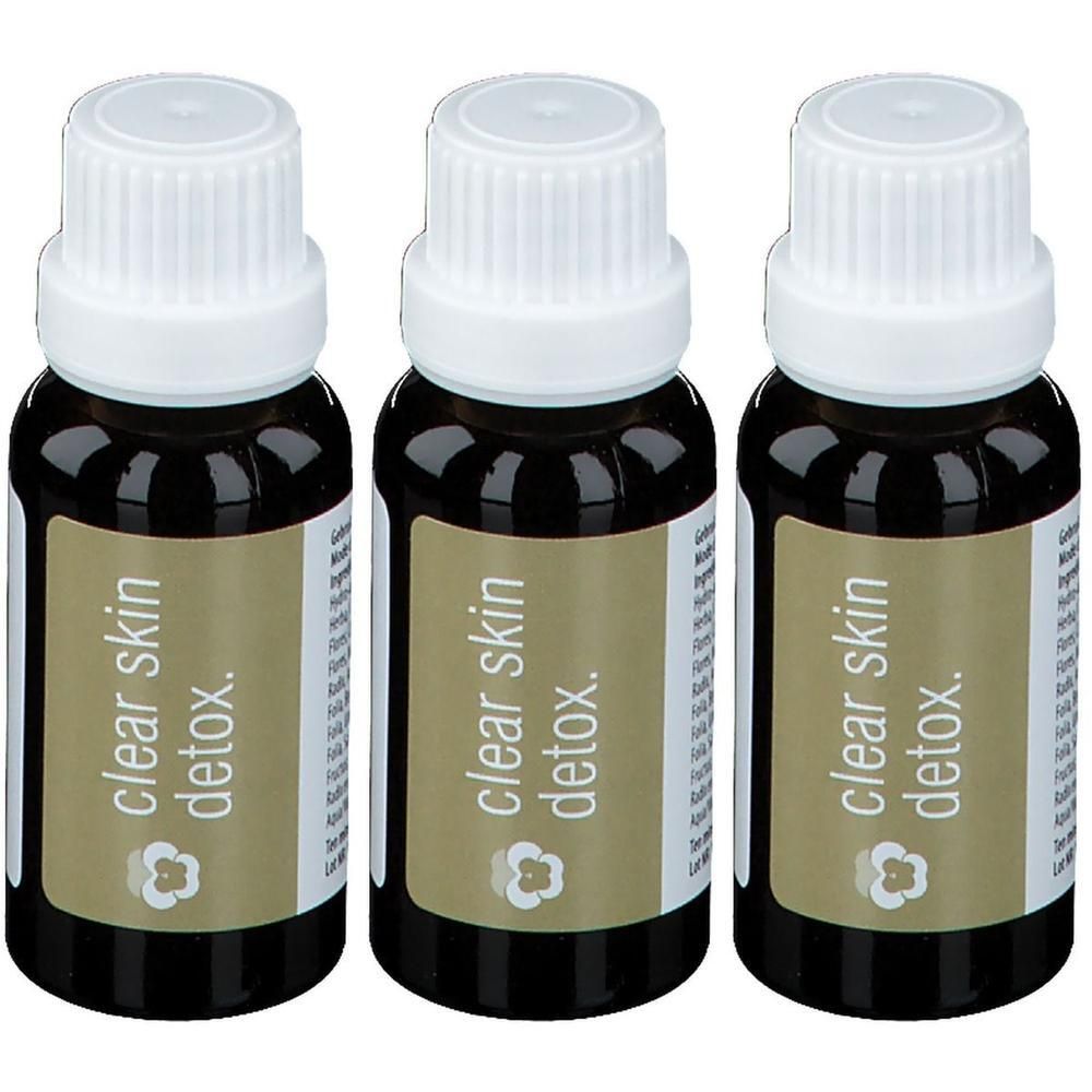 Trois petites bouteilles en verre brun avec bouchons à vis blancs, étiquetées "clear skin detox.".