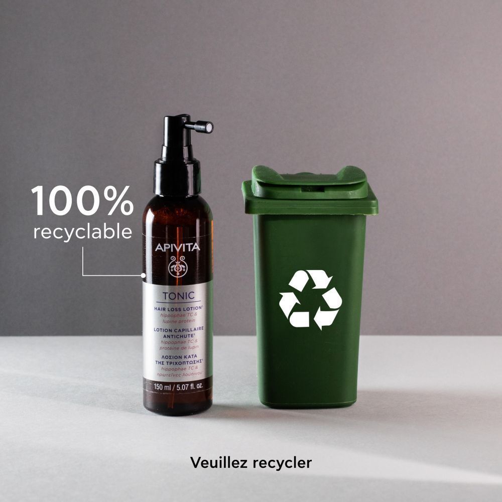 Lotion Apivita Tonic à côté d'une poubelle de recyclage.