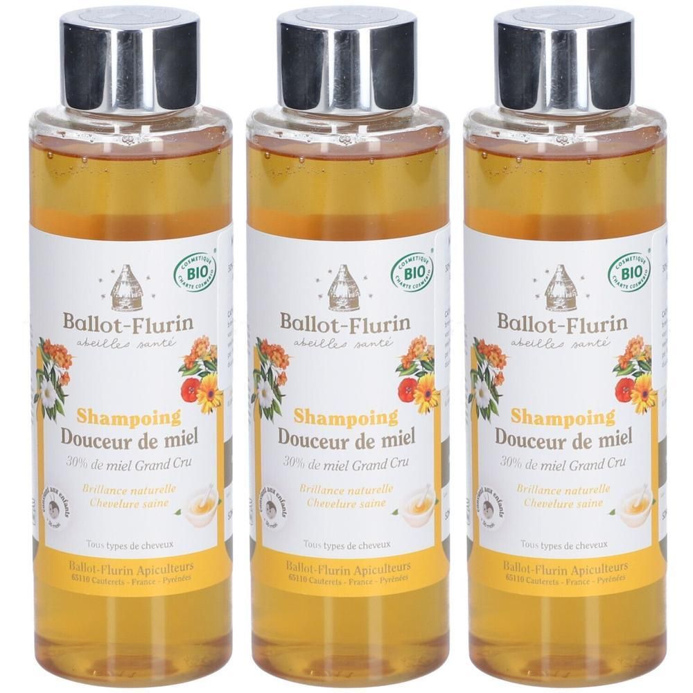 Drie flessen Ballot-Flurin Honing Shampoo met zilveren doppen en bloemen/bijen etiketten.