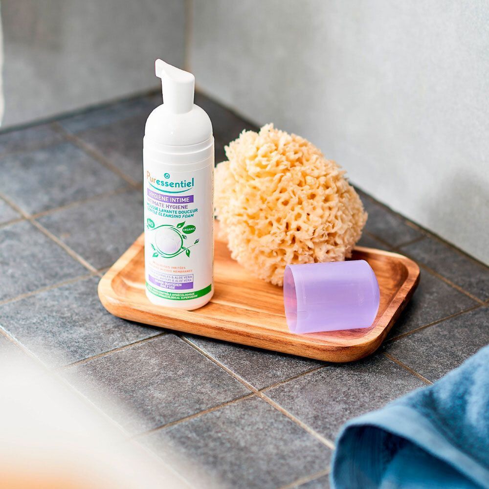 Puressentiel Intieme Hygiëne zachte wasschuim op een houten dienblad met badspons en dop.