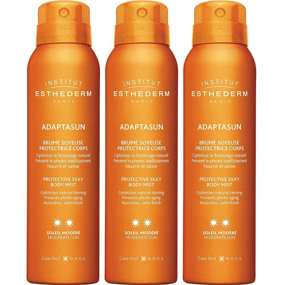 Drie oranje spuitbussen Institut Esthederm Adaptasun voor matige zon.