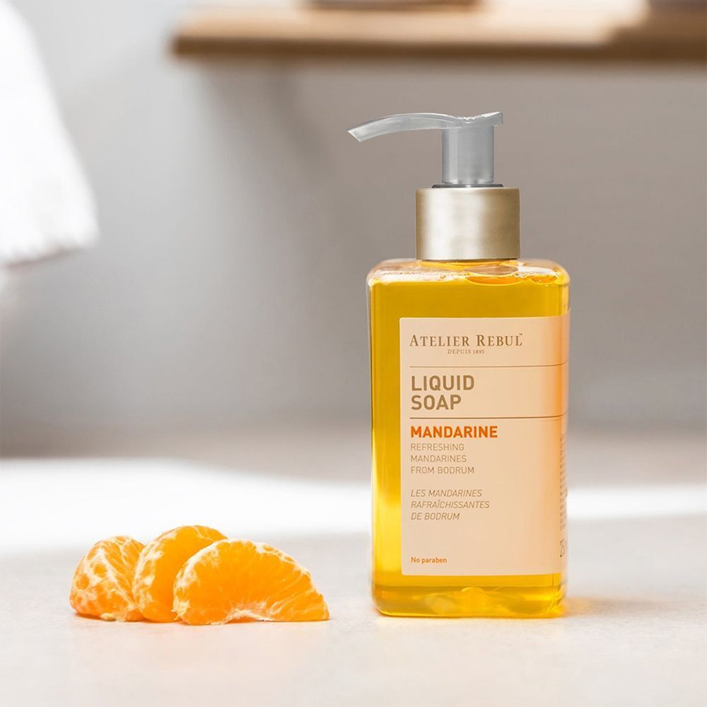 Savon liquide Atelier Rebul Mandarine avec trois morceaux de mandarine.