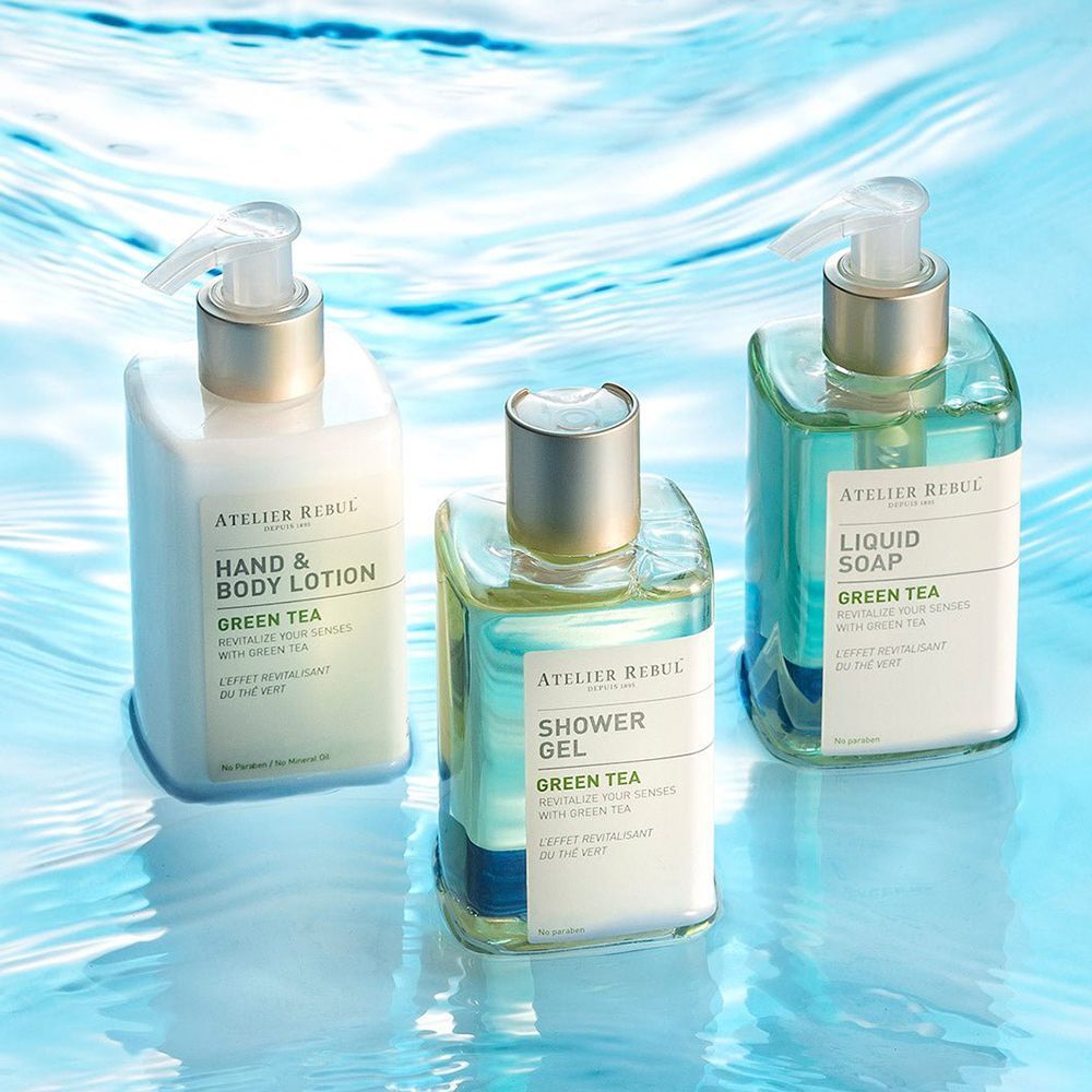Trois flacons Atelier Rebul avec distributeurs à pompe : Lotion mains & corps, gel douche, savon liquide, tous au thé vert.