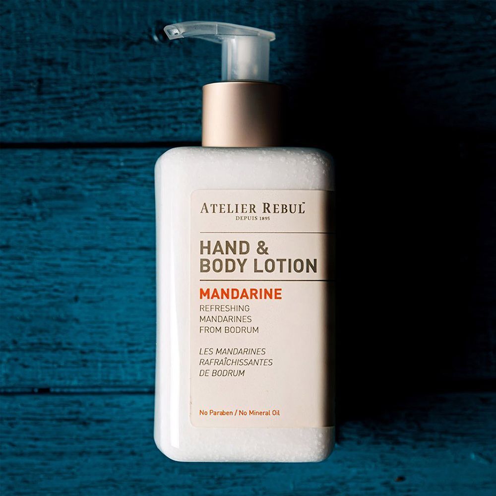 Atelier Rebul Hand & Body Lotion Mandarine in een witte dispenser.