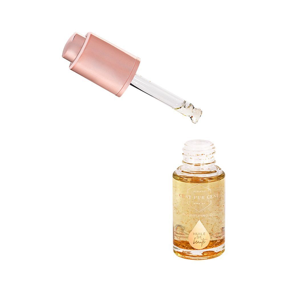 Cent Pur Cent Huile de Beauté fles met druppelaar die een vloeistofdruppel vasthoudt.