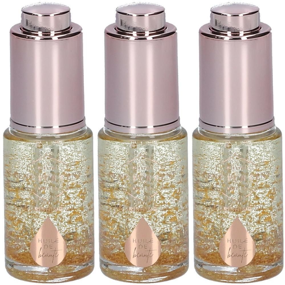 Drie flessen schoonheidsolie met gouden deeltjes en roze dopjes.