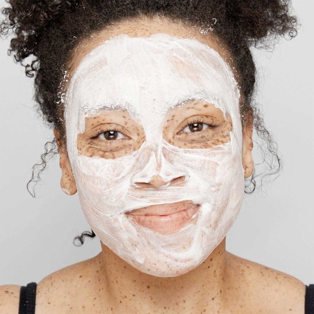 Visage d'une femme aux taches de rousseur, couvert de nettoyant visage moussant.