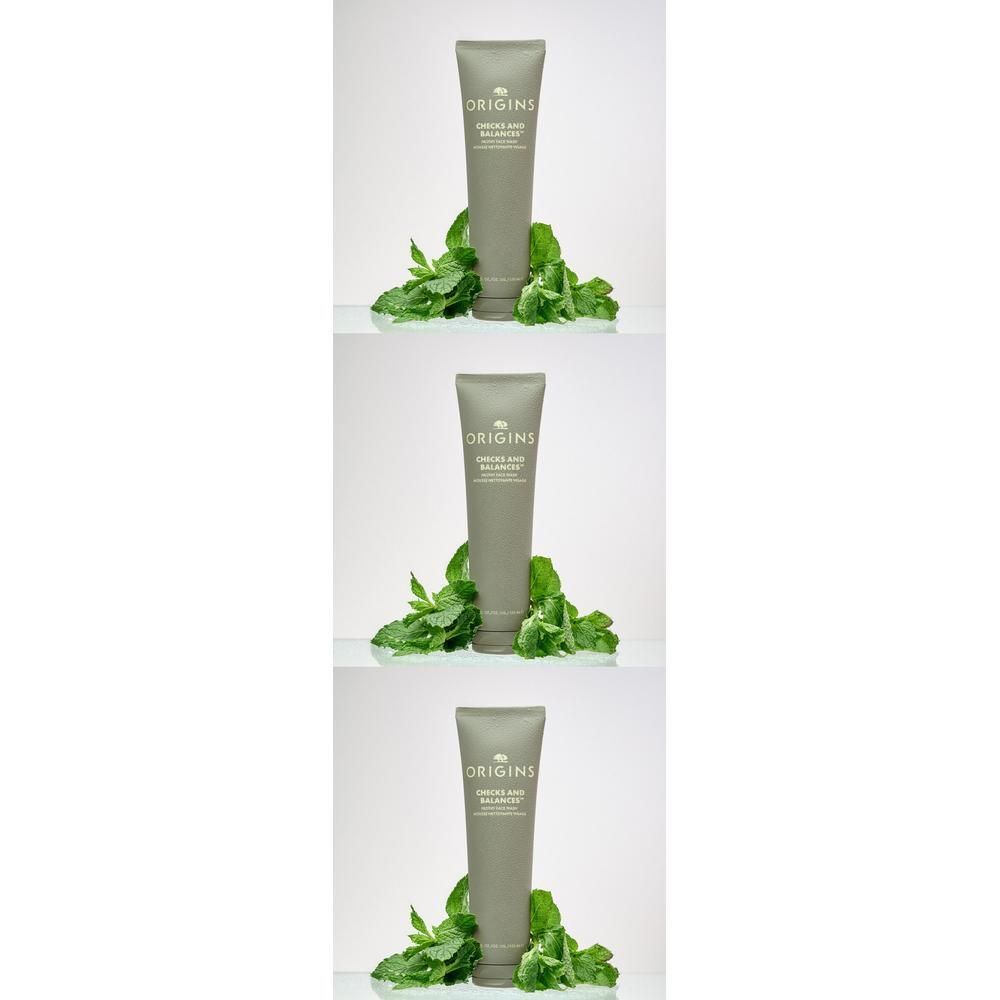 Trois tubes de nettoyant visage Origins avec des feuilles de menthe.