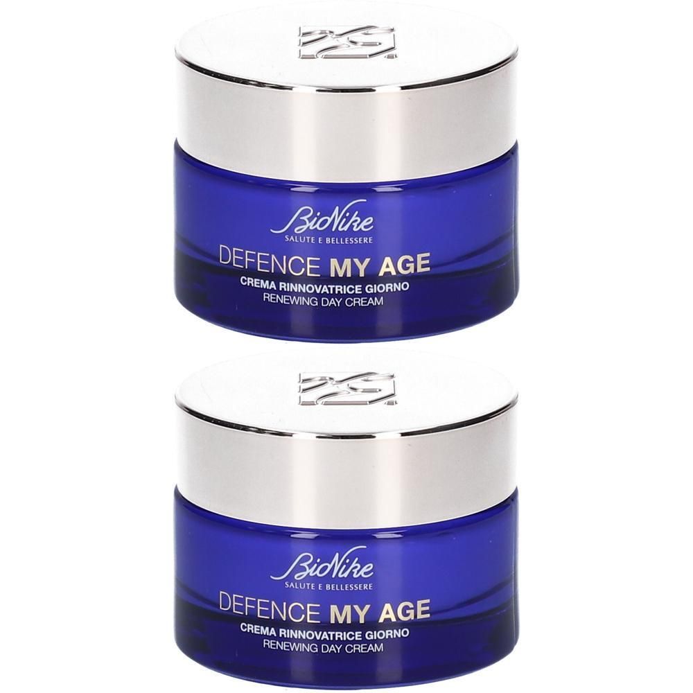 Deux pots de crème de jour BioNike Defence My Age avec des contenants en verre bleu et des couvercles argentés.