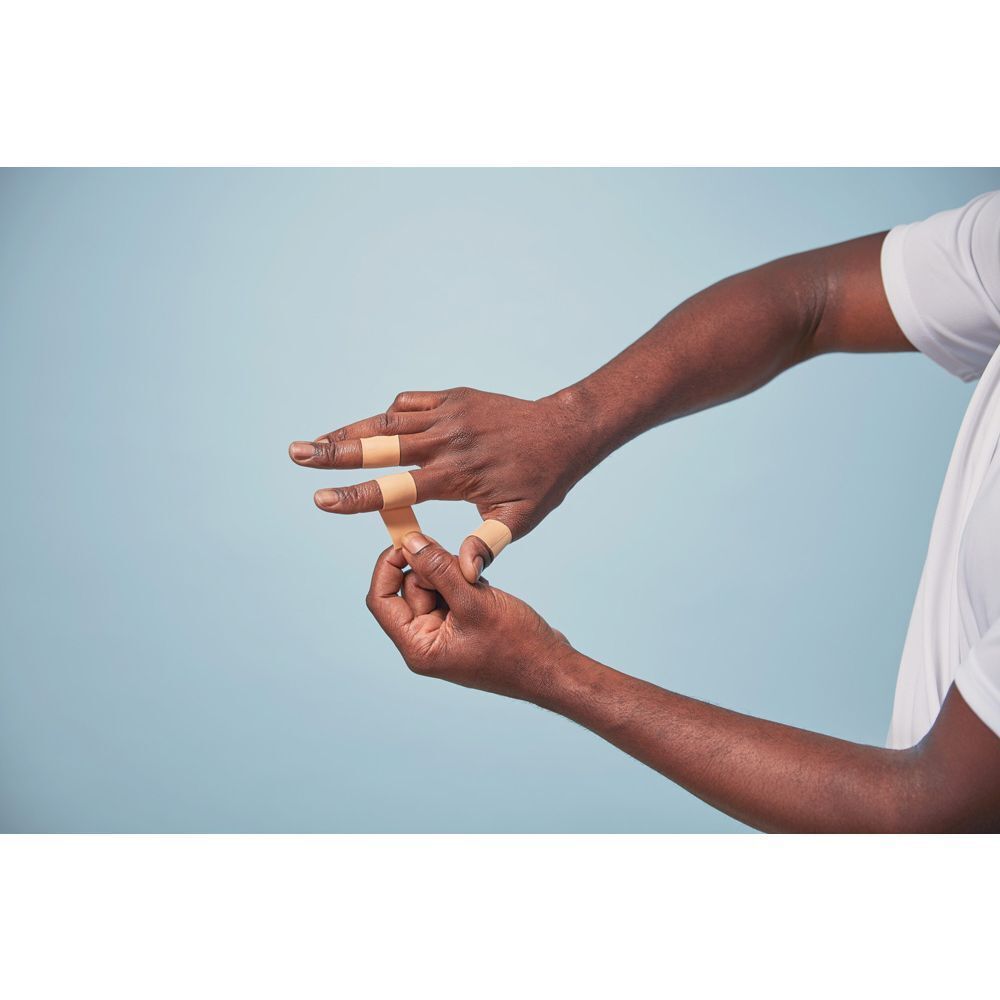 Persoon brengt Nexcare Active Tape aan op vingers.