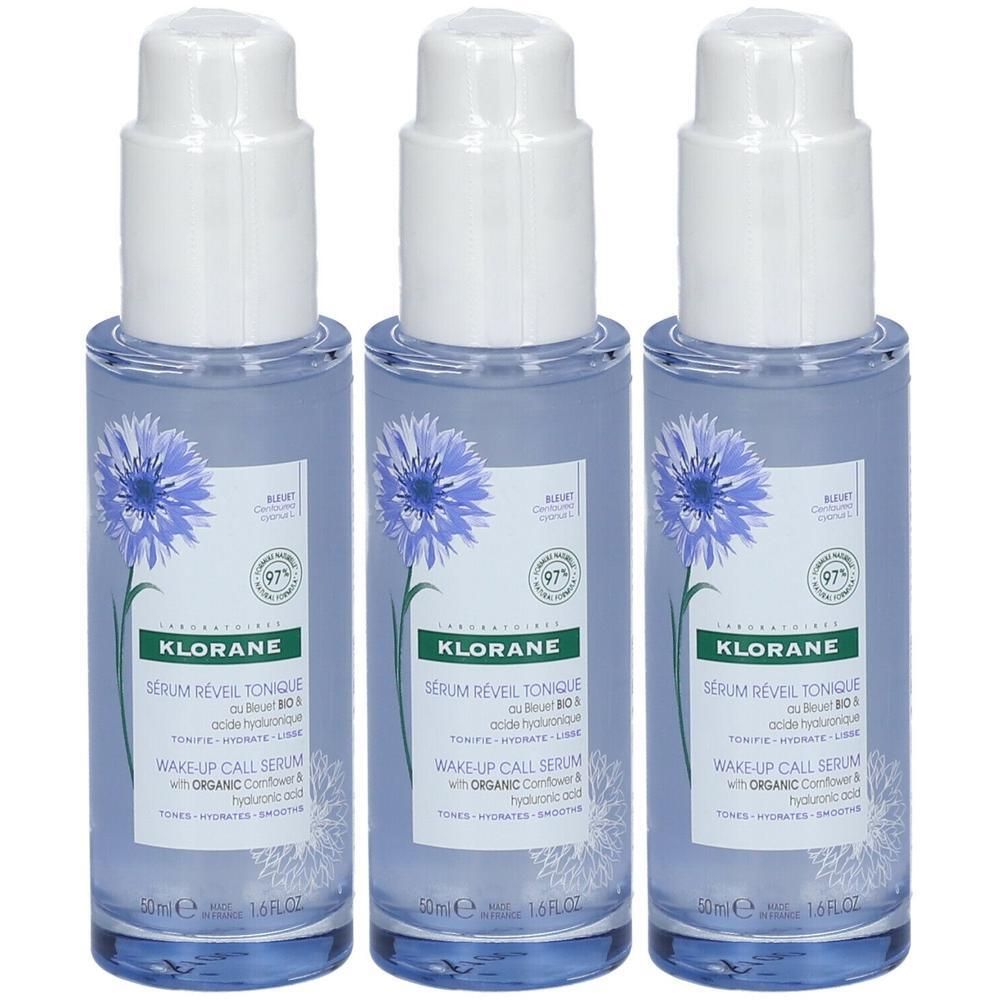 Drie Klorane serums met korenbloemextract en hyaluronzuur in blauwe glazen flacons met pompdosering.