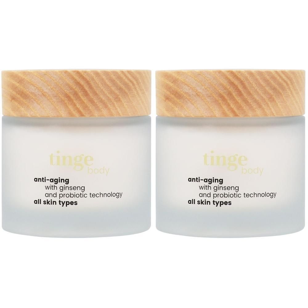 Deux pots de crème corps anti-âge Tinge avec couvercles en bois. Texte : Anti-âge, avec ginseng et technologie probiotique, pour tous types de peau.