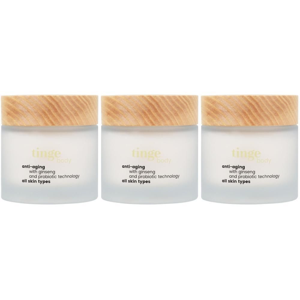 Trois pots de crème corps anti-âge Tinge avec couvercles en bois. Étiquette : Anti-âge, avec ginseng et technologie probiotique, tous types de peau.