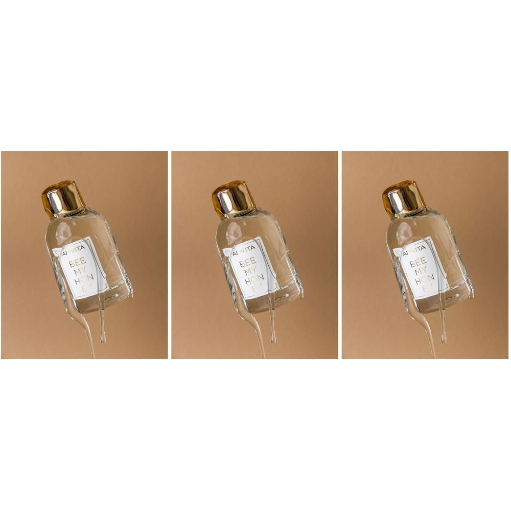 Apivita Bee My Honey Eau de Toilette flesje met gouden dop, omringd door druipende vloeibare elementen.