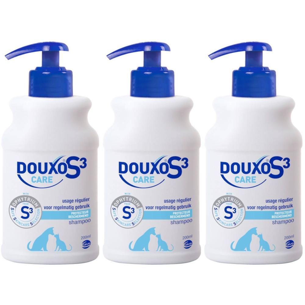Drie witte flessen DOUXO S3 Care Shampoo met blauwe pompen en etiketten.