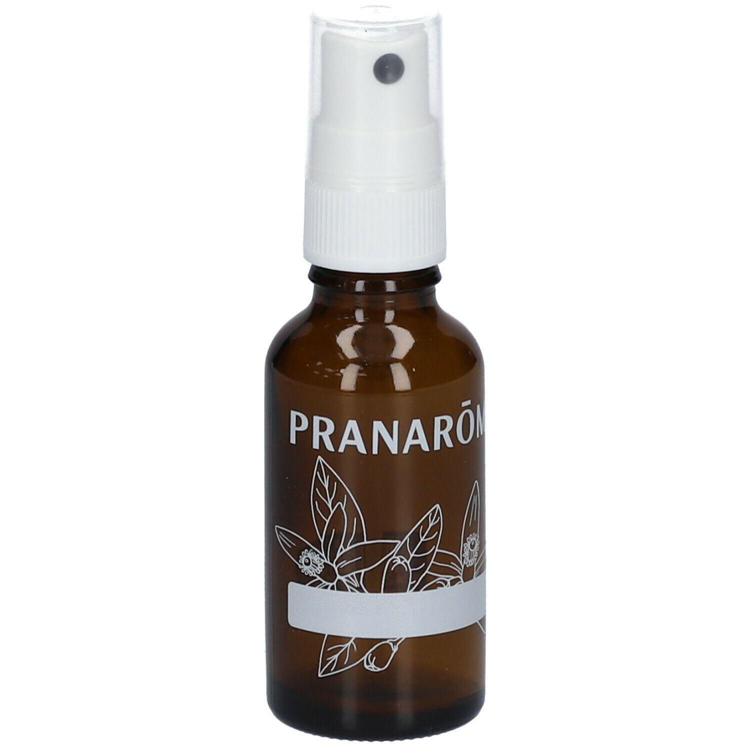 Flacon pulvérisateur brun avec vaporisateur blanc et étiquette blanche ornée d'un motif floral et du nom de marque PRANAROM.
