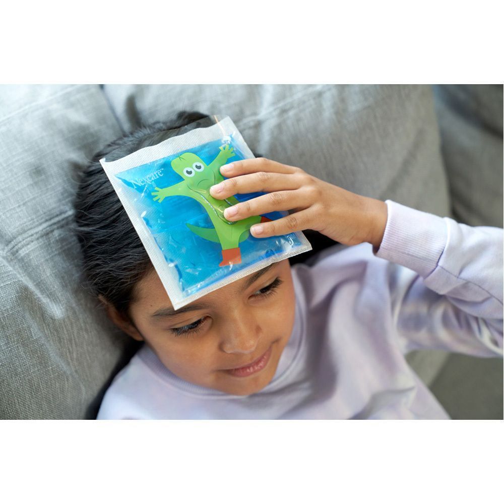 Un enfant avec un pack de thérapie Nexcare Coldhot Happy Kids avec motif de crocodile sur le front.