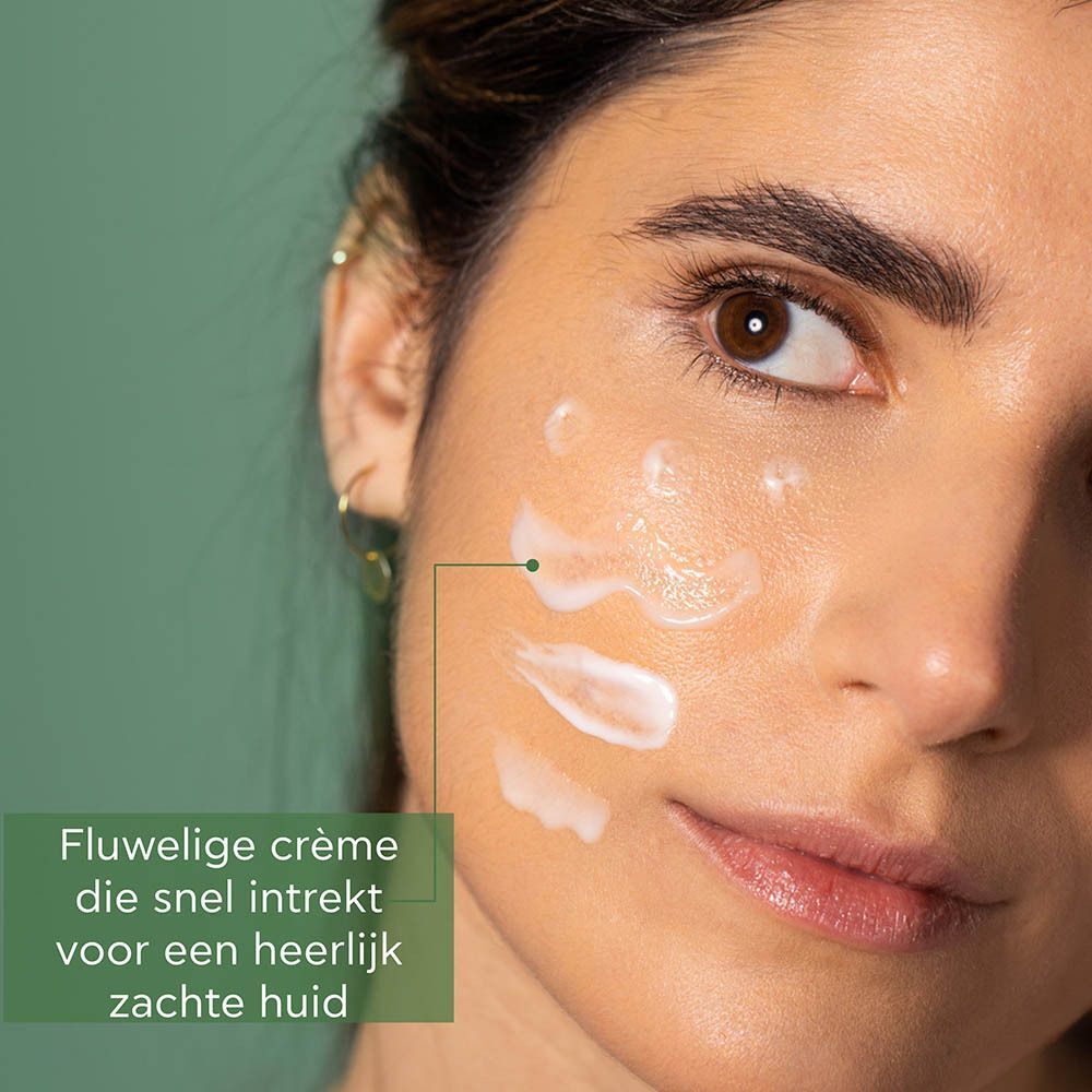 Een vrouw brengt Apivita Bee Radiant crème aan op haar gezicht, die snel intrekt.