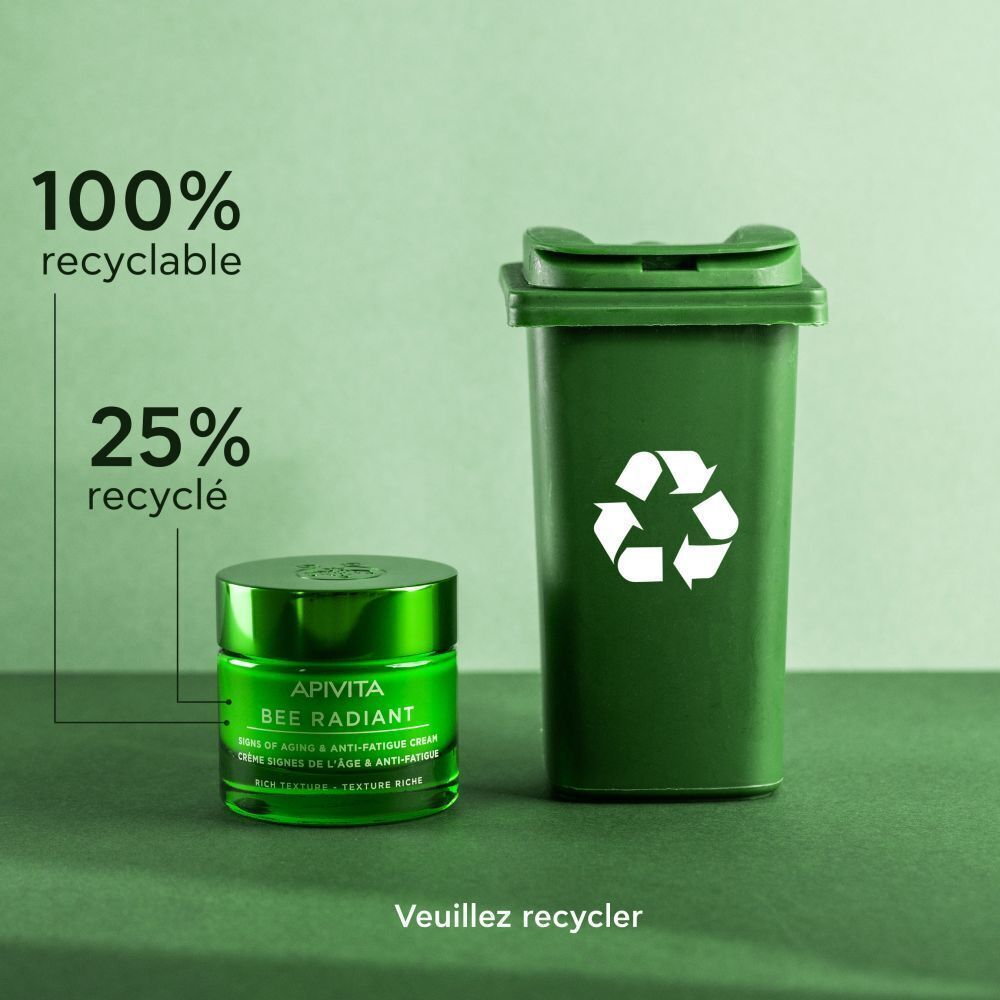 Pot Apivita Bee Radiant à côté d'une poubelle verte. 100% recyclable, 25% recyclé.