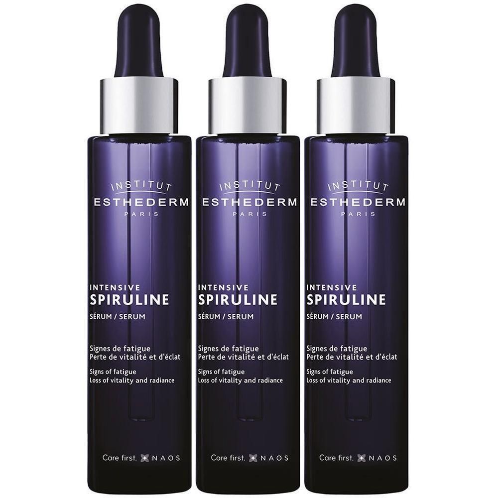 Trois flacons de Sérum Intensif Spiruline Institut Esthederm avec compte-gouttes. Flacons violet foncé avec col argenté.