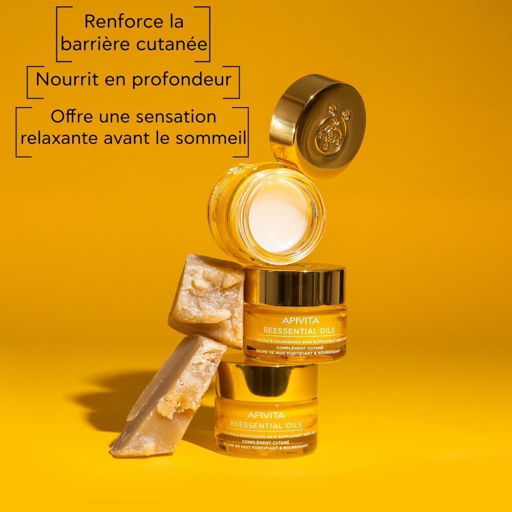 Pots de Baume de Nuit Apivita Beessential Oils empilés, un pot ouvert.