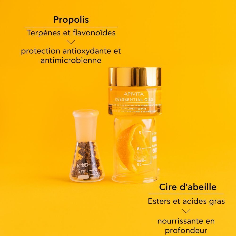Baume de Nuit Apivita Beessential Oils dans un pot avec des ustensiles de laboratoire.