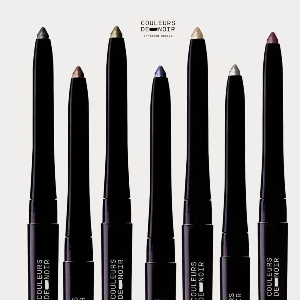 Sept crayons eye-liner noirs de différentes couleurs, disposés verticalement.