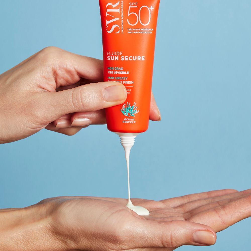 SVR Sun Secure Fluide SPF50+ zonnebrandcrème wordt uit een tube in een handpalm gedoseerd.