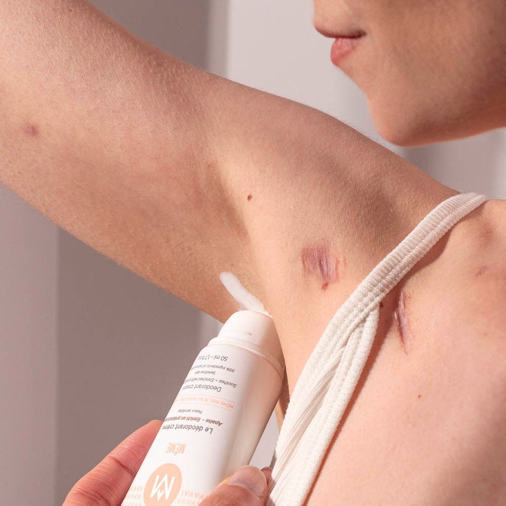 Une main applique le déodorant crème MÊME sur une aisselle.