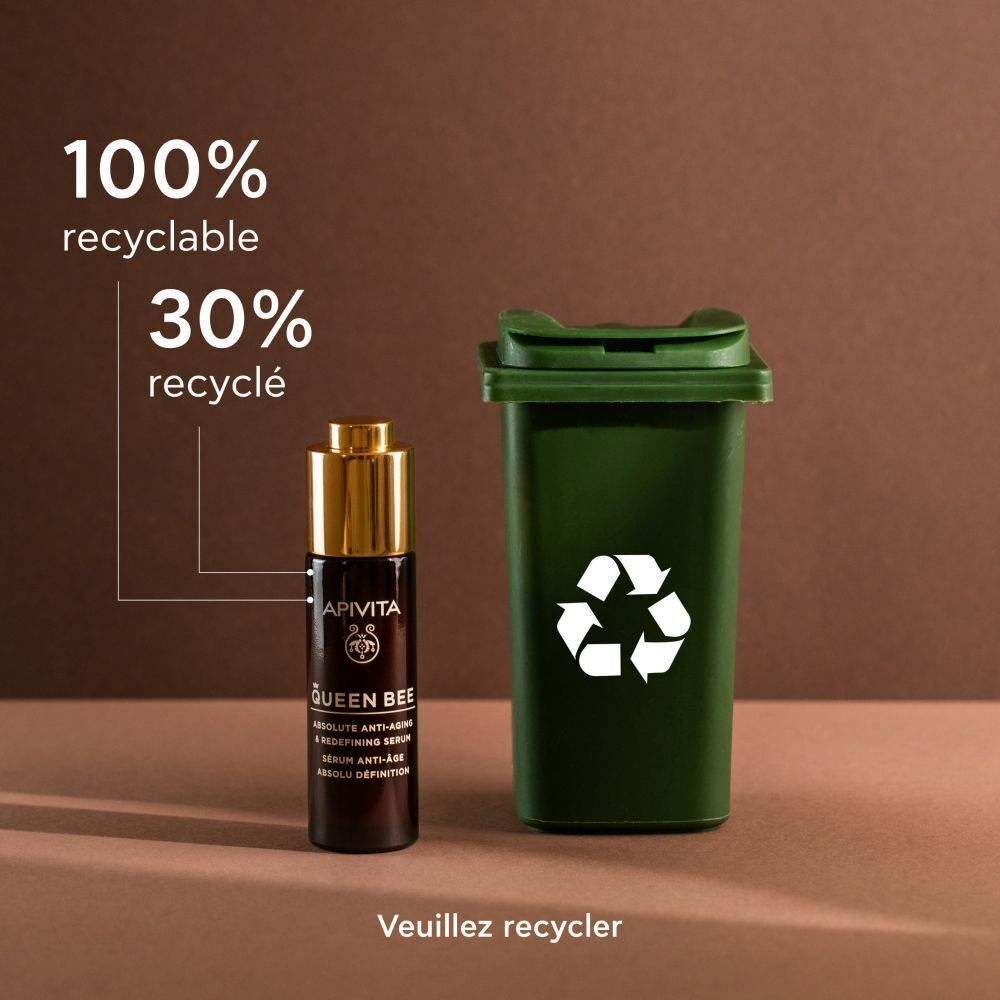 Sérum Apivita Queen Bee à côté d'une poubelle de recyclage verte.