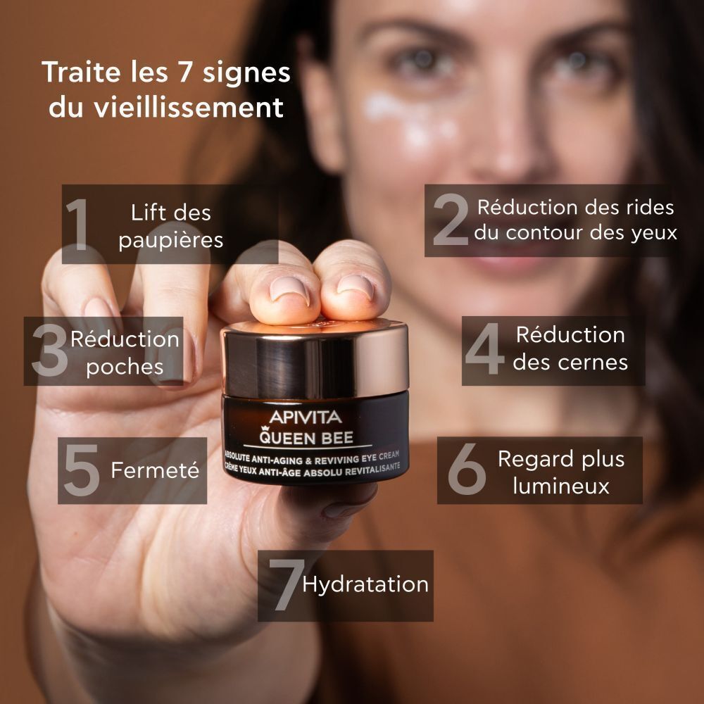 Femme tenant la crème contour des yeux Apivita Queen Bee. Traite 7 signes du vieillissement.