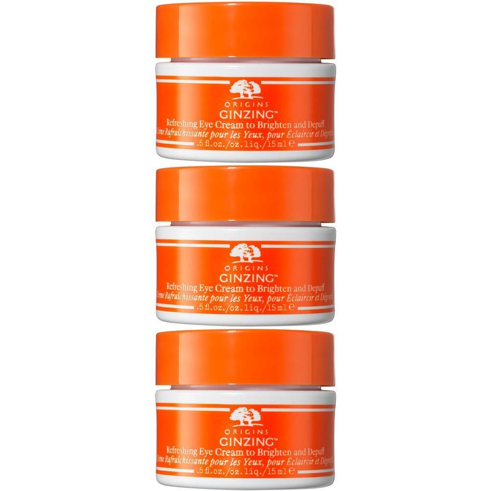 Trois pots de crème pour les yeux Origins GinZing avec couvercles orange.