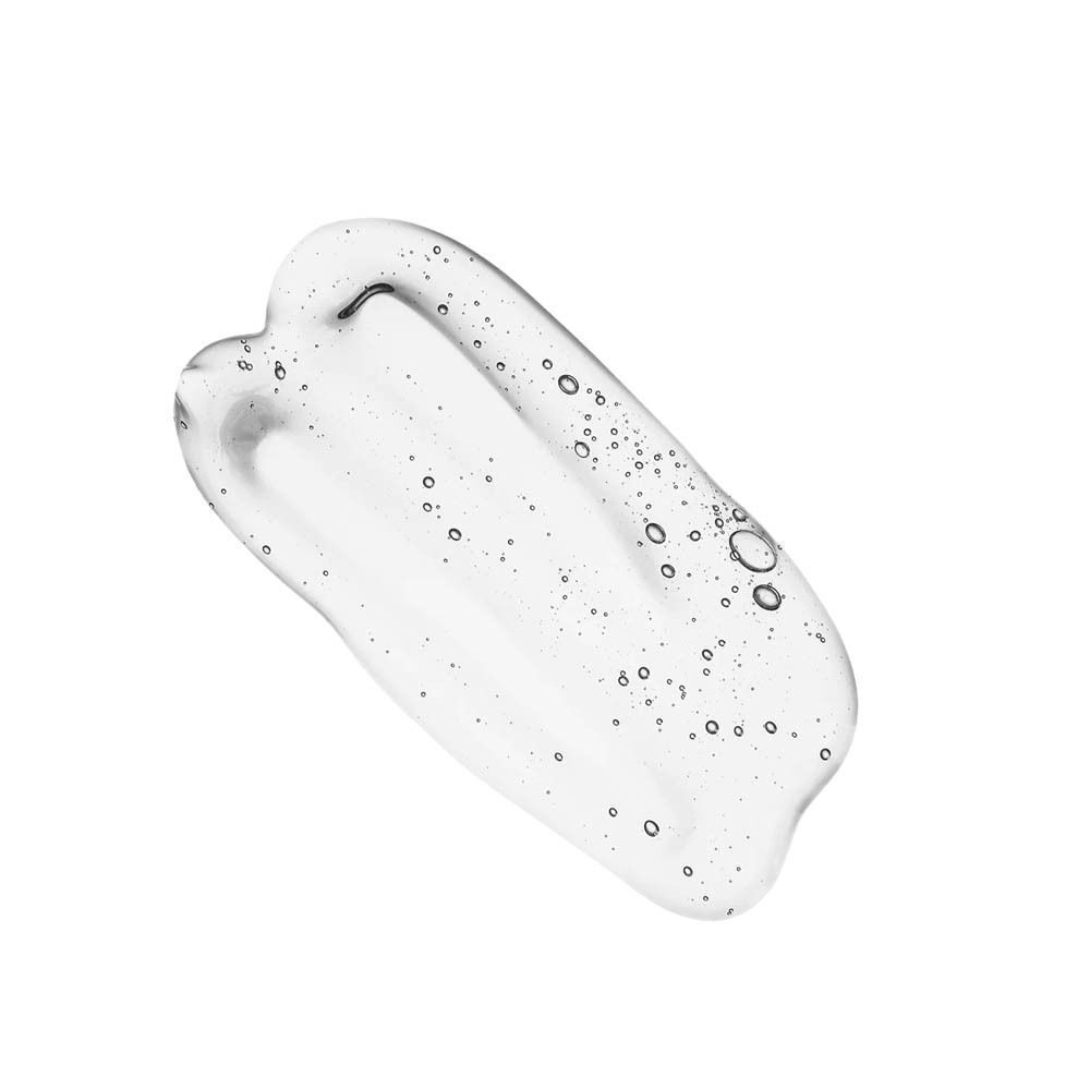 Een heldere, glanzende druppel lipgloss met luchtbelletjes op witte achtergrond.