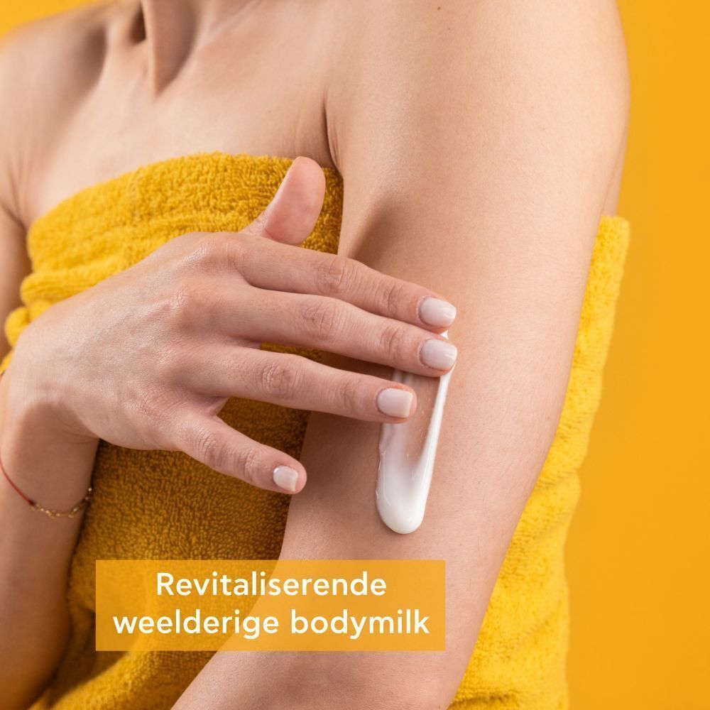 Een persoon brengt Apivita Bee My Honey Body Milk aan op de huid.