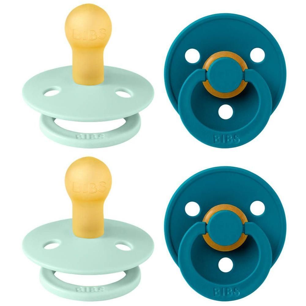 Twee BIBS fopspenen in mintgroen en donkerblauw met gele en gouden handgrepen.