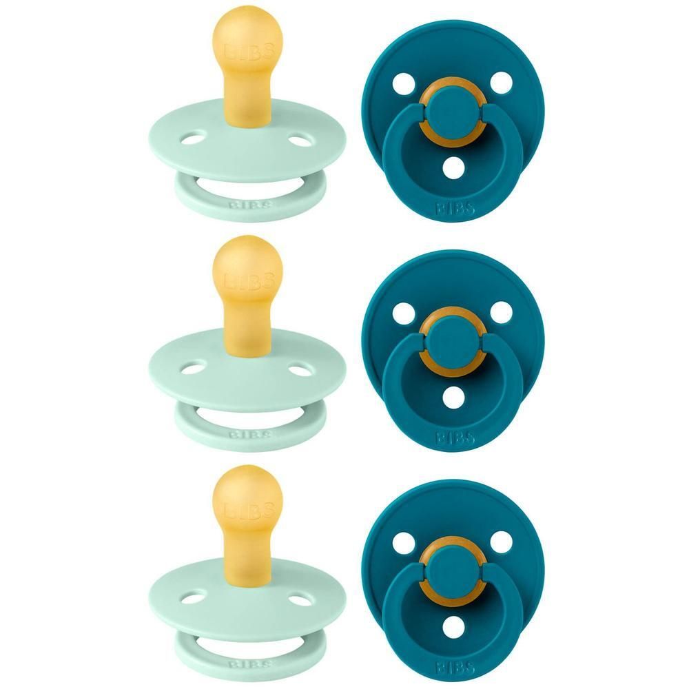 Trois sucettes BIBS vert menthe et bleu foncé avec tétine imitation bois.