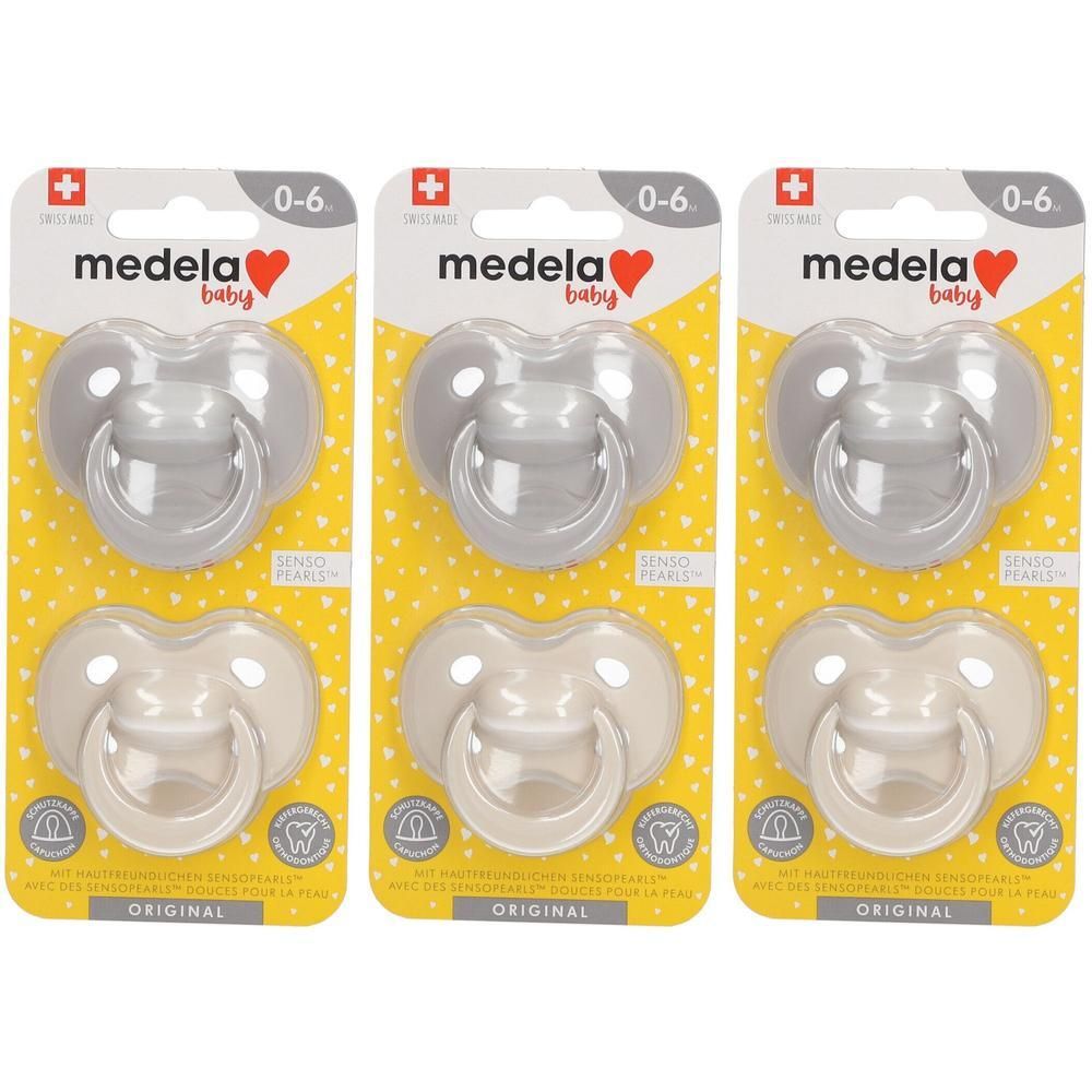 Trois paquets de sucettes Medela Baby Original Pastel, 0-6 mois. Deux paquets gris et un beige.